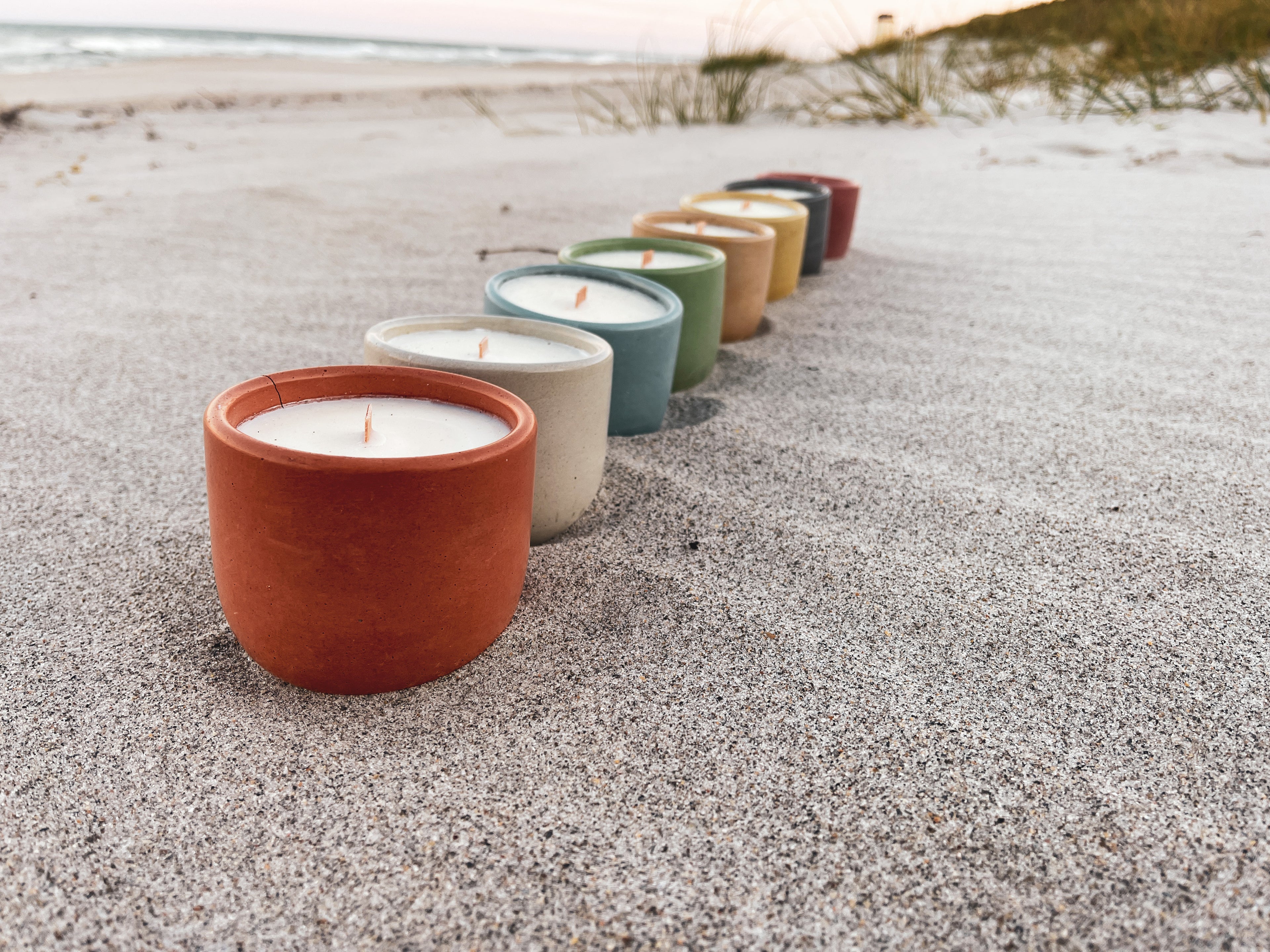 candles lined up on a beach