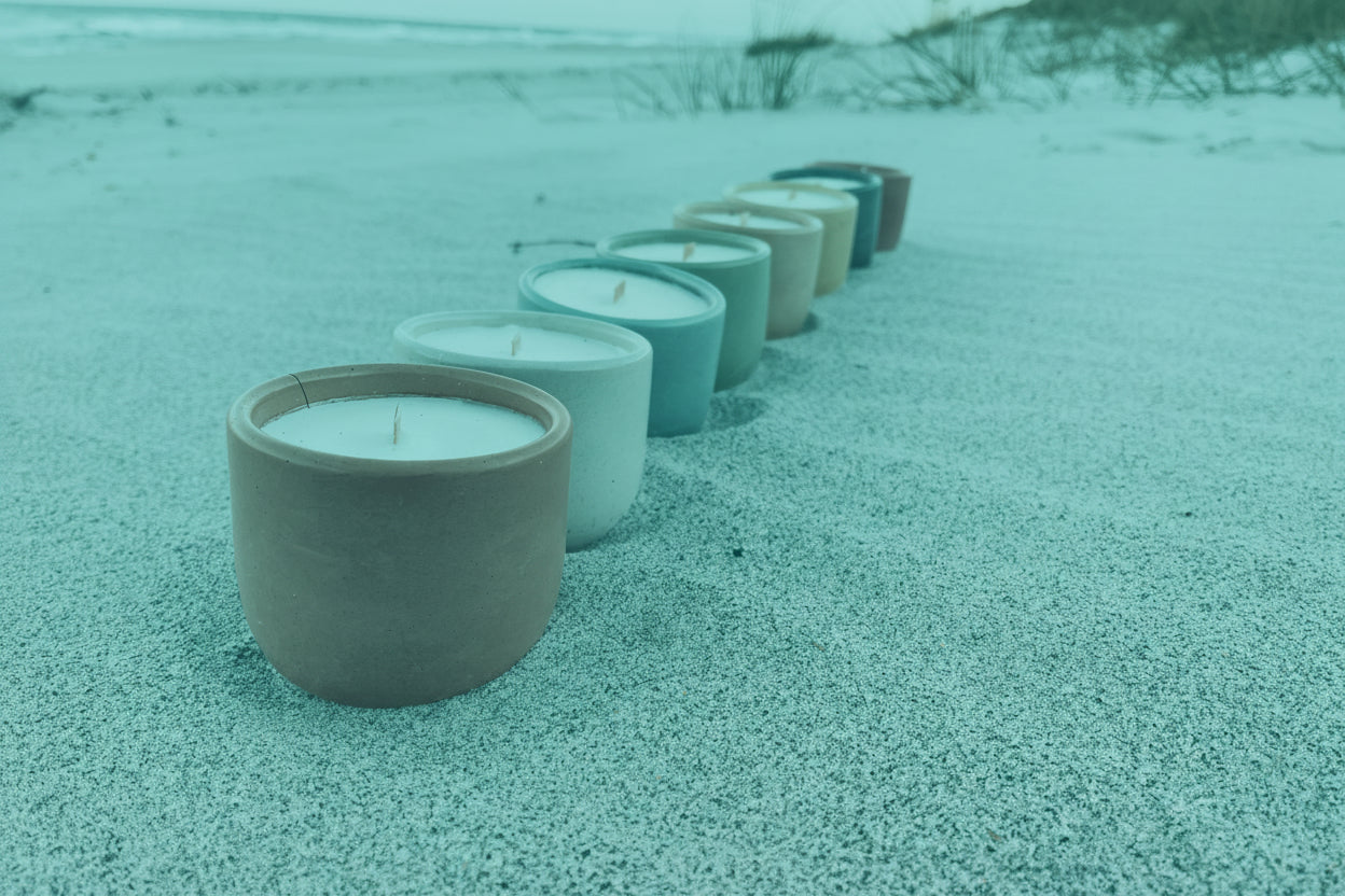 candles lined up on a beach